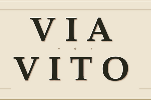Beige sign with 'VIA VITO' text on a beige background